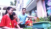 Thầy Lưu Hoàng Phúc hướng dẫn HS cách trồng và chăm sóc rau củ quả tại vườn ươm của trường