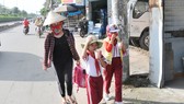 Học sinh một trường tiểu học ở huyện Hóc Môn trên đường về nhà sau giờ tan trường. Ảnh: THÀNH TRÍ