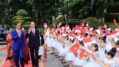 Indonesian President Joko Widodo (L) is welcomed by Vietnamese children at the official welcome ceremony for him and his spouse in Hanoi on September 11 (Photo: VNA)