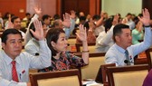 Các đại biểu HĐND TPHCM biểu quyết thông qua nghị quyết kỳ họp..Ảnh: VIỆT DŨNG