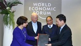PM Nguyen Xuan Phuc (blue tie) and WEF Founder and Executive Chairman Klaus Schwab witness the signing of an agreement between the WEF and Vietnam on building a centre for the Fourth Industrial Revolution. (Photo: VNA)
