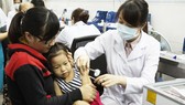 Phụ huynh đưa con đi chích ngừa tại Viện Pasteur