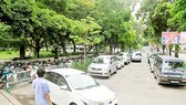 Ô tô đậu trên vỉa hè công viên Lê Văn Tám phía đường Hai Bà Trưng. Ảnh: THÀNH TRÍ