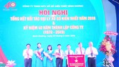 Ông Nguyễn Hoàng Thao (bìa trái), Phó Bí thư Thường trực Tỉnh ủy và ông Đặng Minh Hưng (bìa phải), Phó Chủ tịch UBND tỉnh trao Cờ thi đua của Thủ tướng Chính phủ cho Công ty TNHH MTV Xổ số kiến thiết Bình Dương