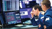Nhân viên giao dịch theo dõi chỉ số chứng khoán tại Sàn giao dịch chứng khoán New York (Mỹ)