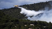 A fire fighting Canadair aircraft drops water over a fire in Mirabeau, southeastern France, on Monday -AFP/VNA