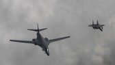A U.S. B-1B bomber (L) flies over Korea along with a South Korean F-15K fighter on July 30, 2017 in this photo provided by the Air Force. (Yonhap)