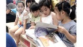 Bạn đọc nhí thích thú cuốn sách Thiện và Ác và Cổ tích - sách Artbook do NXB Kim Đồng ấn hành