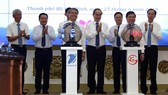 Lãnh đạo TPHCM bấm nút triển khai hệ thống “Phòng họp không giấy” và ứng dụng “Giao việc tức thời - nhắc việc thông minh”. Ảnh: TTXVN