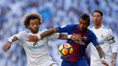 Marcelo (trái, Real Madrid) tranh bóng với Paulinho (Barcelona)