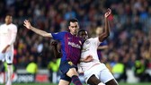 Sergio Busquets tranh bóng với Paul Pogba (phải)