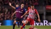 Rodri đi bóng trước Sergio Busquets của Barcelona.