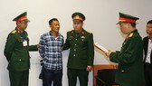 Cơ quan Điều tra hình sự Bộ Quốc phòng thông báo và tống đạt các quyết định tố tụng đối với bị can Hùng. Ảnh: BQP
