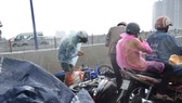 Người dân lưu thông trên cầu té ngã vì đường trơn trượt trong cơn mưa lớn. Ảnh: C.T