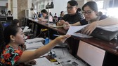 Doanh nghiệp nêu thắc mắc với nhân viên Cục Thuế TPHCM. Ảnh: CAO THĂNG