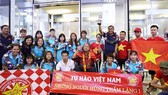 HLV Mai Đức Chung và các cầu thủ về sân bay Nội Bài chụp ảnh cùng người hâm mộ. Ảnh: Minh Hoàng