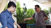 Nhà sáng chế “chân đất” Nguyễn Quang Ngọc (bìa phải) và cộng sự bên những cây lên xanh tốt với chậu trồng cây không cần tưới
