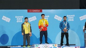 Lực sĩ Ngô Sơn Đỉnh (giữa) trên bục nhận HCV Olympic trẻ.