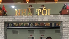 My Home: Trang stands with customers outside her restaurant.— Photo courtesy of Nguyen Thi Dai Trang