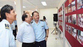 Tat Thanh Cang, Standing Deputy Secretary of the municipal Party Committee, looks at pictures featuring customs activities (Photo: SGGP)