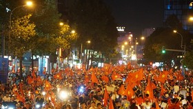 Football fans with national flags, trumpets and drums flock to streets cheering the victory