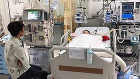 Cha của 2 bé đang thấp thỏm bên giường bệnh