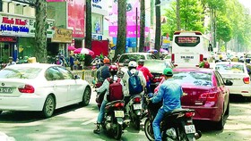 Cổng Bệnh viện Từ Dũ bị lấn chiếm nên các ô tô phải đón khách dưới lòng đường, gây khó khăn cho người tham gia giao thông
