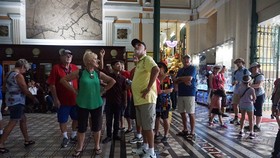 A tour guide with a group of tourists at the Central Post Office in HCM City. Photo: VNS