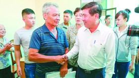 Chairman Nguyen Thanh Phong shakes hands with a residents at a meeting with people relating to Thu Thiem new urban area on October 18 (Photo: SGGP)