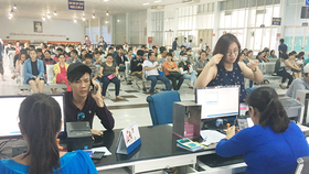 Người dân lấy số thứ tự chờ mua vé tàu Tết tại ga Sài Gòn