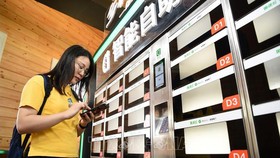 Người dân mua đồ ăn nhanh bằng dịch vụ thanh toán qua điện thoại ở Trùng Khánh, Trung Quốc ngày 23-8-2018. Ảnh: THX