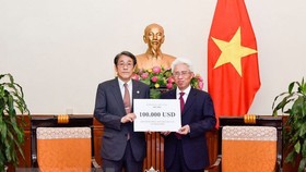 Đại diện Bộ Ngoại giao đã trao cho Đại sứ Nhật Bản tại Việt Nam khoản hỗ trợ. (Ảnh: TTXVN )