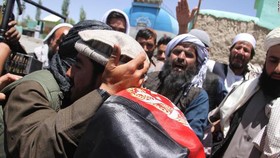 Chiến binh Taliban và người Afghanistan ôm nhau tại Ghazni ngày 16-6. Ảnh: CNN