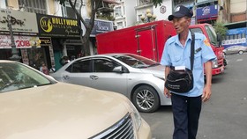 Nhân viên thu phí đậu xe khu vực chợ Bến Thành. Ảnh: VIỆT DŨNG