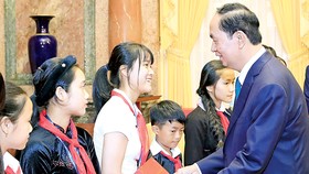 Chủ tịch nước Trần Đại Quang tặng quà các trẻ em có hoàn cảnh đặc biệt. Ảnh: TTXVN