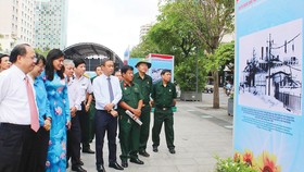 Phó Bí thư Thường trực Thành ủy TPHCM Tất Thành Cang cùng các đại biểu xem triển lãm