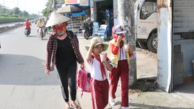 Học sinh một trường tiểu học ở huyện Hóc Môn trên đường về nhà sau giờ tan trường. Ảnh: THÀNH TRÍ