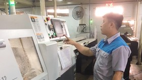Một doanh nghiệp cơ khí tại quận 8, TPHCM, đầu tư dây chuyền tự động sản xuất bình xăng con xe máy để cạnh tranh với hàng nhập lậu. Ảnh: DŨNG LÊ