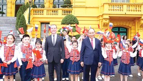 Thủ tướng Nguyễn Xuân Phúc và Thủ tướng Liên bang Nga Dmitry Medvedev chụp ảnh chung với thiếu nhi Hà Nội tại lễ đón. Ảnh: TTXVN
