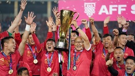ietnam's football team pose for a photo with the AFF Suzuki Cup trophy. (Photo: VNA)