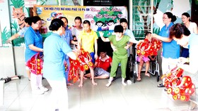 Chi hội Phụ nữ khu phố 10 (phường 4, quận 8, TPHCM) trao quà tặng các em tại Trung tâm Bảo trợ trẻ tàn tật - mồ côi Thị Nghè. Ảnh: MINH THẢO