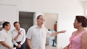 Bí thư Thành ủy TPHCM Nguyễn Thiện Nhân thăm hỏi người dân Thủ Thiêm đồng ý lên ở khu chung cư tái định cư. Ảnh: VIỆT DŨNG
