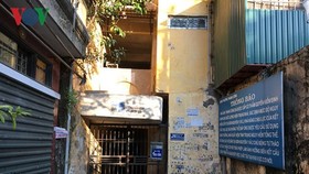 Người dân khóa cửa ra vào cầu thang, ngay bên cạnh biển báo nguy hiểm.