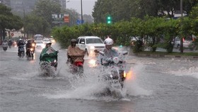 Các phương tiện lưu thông trong tình trạng ngập nước mỗi khi mưa lớn tại đường Nguyễn Hữu Cảnh, quận Bình Thạnh. (Ảnh: Xuân Dự/TTXVN)