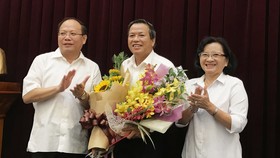 Đồng chí Tất Thành Cang và đồng chí Thân Thị Thư, Ủy viên Ban Thường vụ Thành ủy TPHCM, trao quyết nghỉ hưu và tặng hoa cho đồng chí Huỳnh Văn Chúm (giữa). Ảnh: KIỀU PHONG