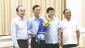 Phó Chủ tich UBND TPHCM Huỳnh Cách Mạng (thứ hai từ phải sang) và ông Hồ Văn Ngon (thứ ba từ phải sang) tại buổi trao quyết định. Ảnh: KIỀU PHONG