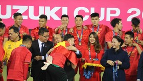 Thủ tướng Nguyễn Xuân Phúc chúc mừng từng thành viên của đội tuyển Việt Nam trên bục trao Cúp vô địch. Ảnh: DŨNG PHƯƠNG