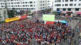 Fans gather outdoor to watch a football match (Photo: VNA)