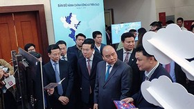 Prime Minister Nguyen Xuan Phuc, Head of the Central Propaganda Department of the Communist Party of Vietnam Vo Van Thuong, and Minister of Information and Communications Nguyen Manh Hung visited an exhibition booth on ICT achievements in the meeting