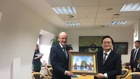Vietnamese Minister of Education and Training Phung Xuan Nha (R) presents a gift to Minister of State at the UK Department for Education Nick Gibb (Photo: VNA)